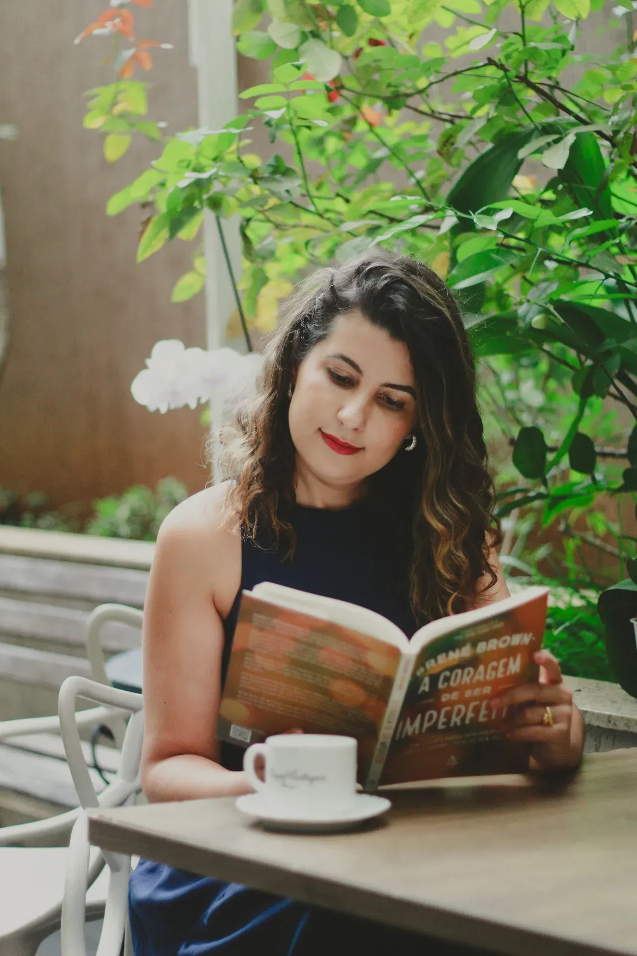 Raquel Eustáquia lendo livro em ambiente externo