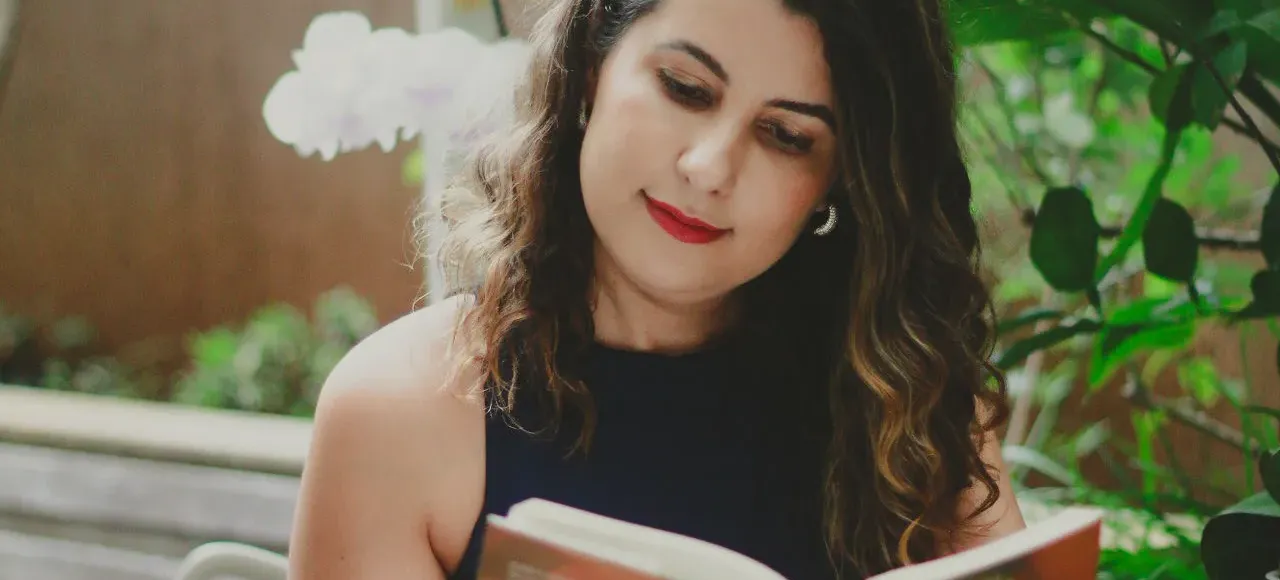 Raquel Eustáquia lendo livro em ambiente externo